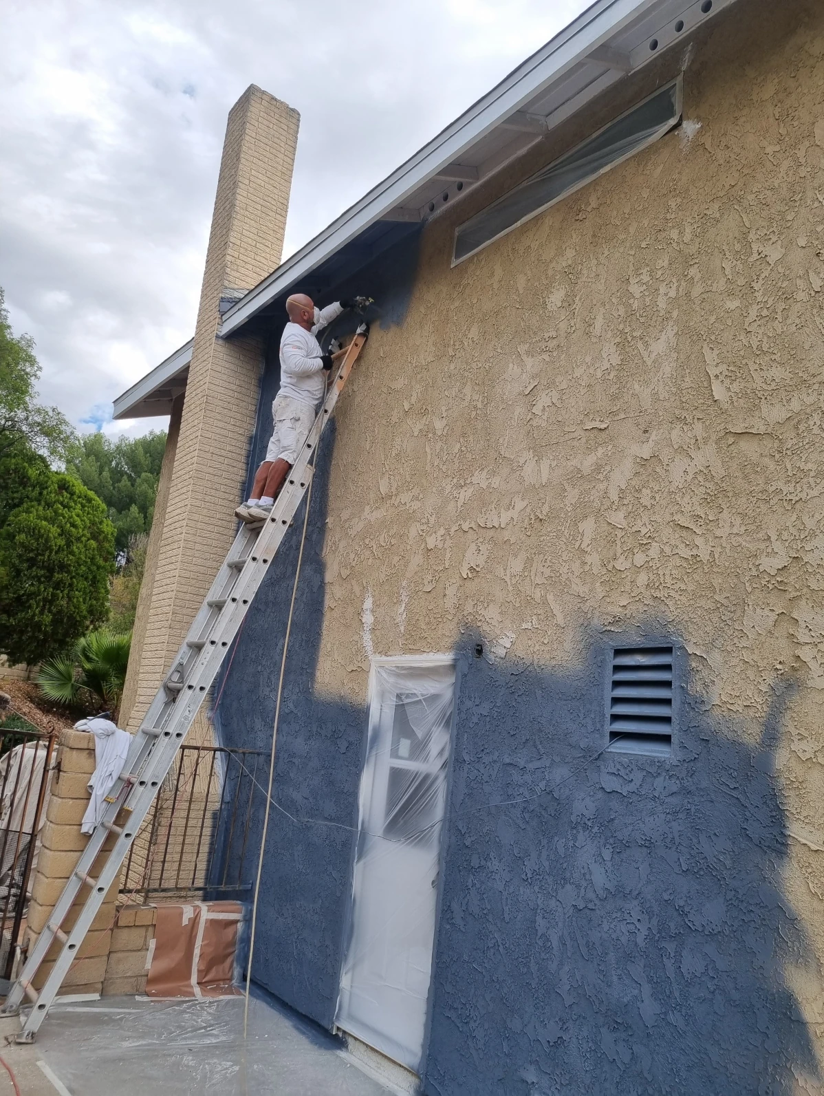 Sky Painting Corp team painting residential exterior on job site